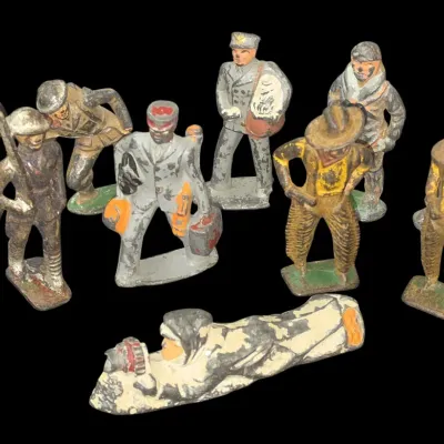 Sale Photo Thumbnail #136: Collection of 10 vintage cast lead or iron toy figurines, featuring military personnel, cowboys, and workers with visible paint wear and patina.