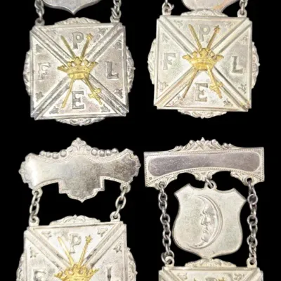 Sale Photo Thumbnail #158: Set of four antique Pythian Sisters or Knights of Pythias fraternal badges with silver and gold-toned detailing.