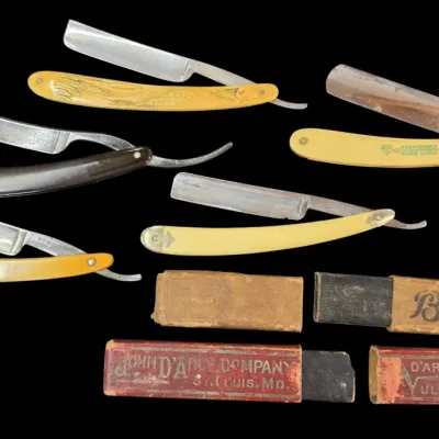 Sale Photo Thumbnail #131: Collection of vintage straight razors with celluloid and horn handles, accompanied by original cardboard storage boxes.