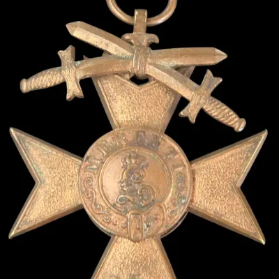 Sale Photo Thumbnail #133: Antique bronze or brass military medal featuring a Maltese cross, crossed swords emblem, and central crowned crest detail.
