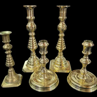 Sale Photo Thumbnail #104: Collection of five traditional brass candlesticks in assorted heights and designs, including two tall matching baluster-style pairs and smaller single holders.