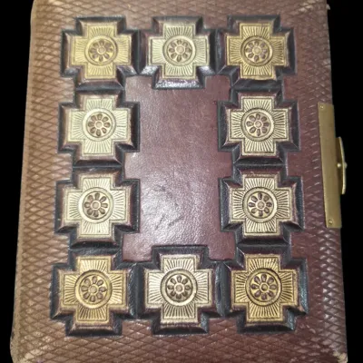 Sale Photo Thumbnail #144: Antique 19th-century embossed leather photo album with brass clasp and raised, gilded cross motifs.