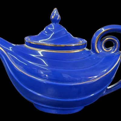 Sale Photo Thumbnail #103: Vintage cobalt blue ceramic teapot featuring a genie lamp shape with gilded gold trim along the edges.