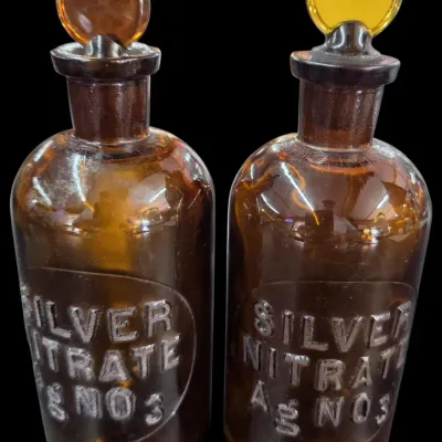 Sale Photo Thumbnail #99: Pair of vintage amber glass apothecary bottles with stoppers, featuring embossed lettering for Silver Nitrate Ag NO3.