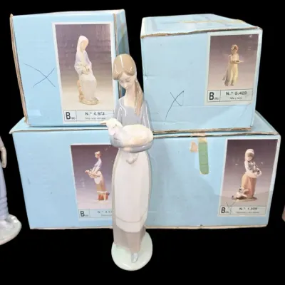 Sale Photo Thumbnail #159: Collection of three Lladró porcelain figurines featuring young women with original light blue branded boxes.