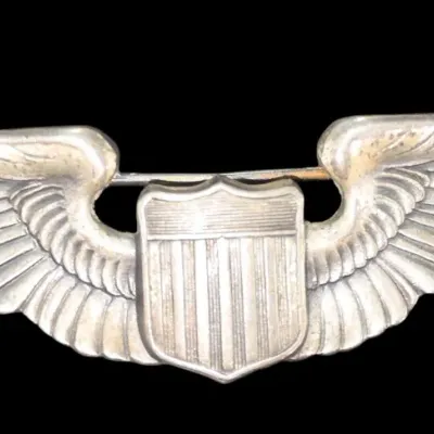 Sale Photo Thumbnail #139: Vintage sterling silver US military pilot wings badge featuring a central shield emblem with detailed feather engravings and a pin-back closure.