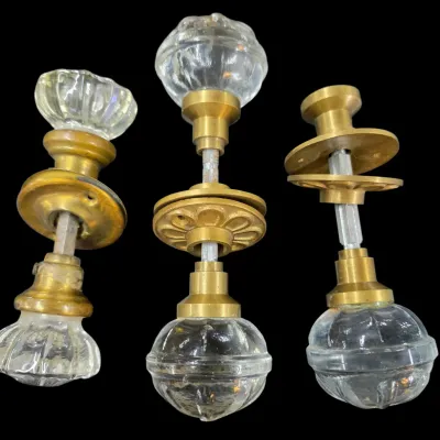 Sale Photo Thumbnail #164: Set of three vintage glass and brass door knob assemblies with connecting spindles and backplates.