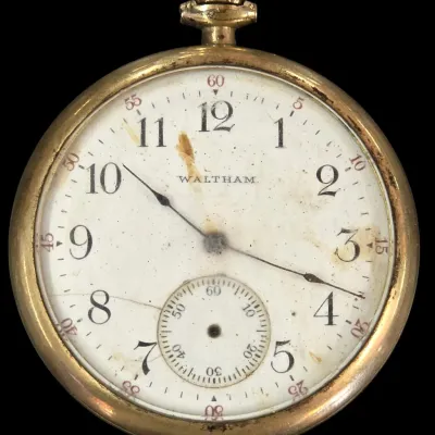 Sale Photo Thumbnail #127: Vintage Waltham open-face pocket watch featuring a gold-tone case, white enamel dial with Arabic numerals, and a sub-seconds dial.