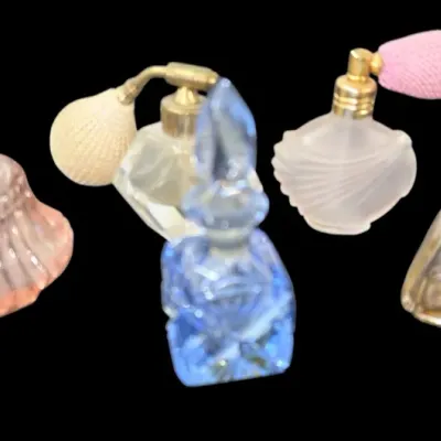 Sale Photo Thumbnail #160: Collection of vintage glass perfume bottles, including several atomizer sprayers with fabric bulbs and a blue cut-glass bottle with a dabber stopper.