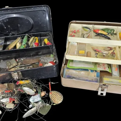 Sale Photo Thumbnail #48: Two vintage metal tackle boxes filled with an assortment of fishing lures, spinners, line, and tackle accessories.