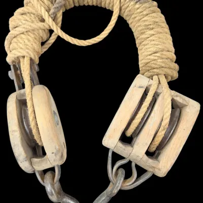 Sale Photo Thumbnail #151: Vintage block and tackle pulley set featuring weathered wooden shells, iron sheaves and hooks, strung with natural fiber rope.