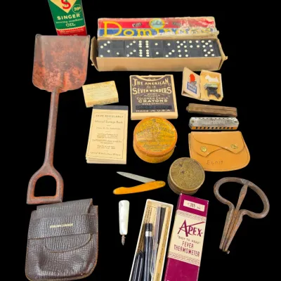 Sale Photo Thumbnail #87: Collection of vintage smalls including a rusty metal hand shovel, a boxed set of dominoes, Singer sewing machine oil, a fever thermometer, pocket knives, and advertising ephemera.