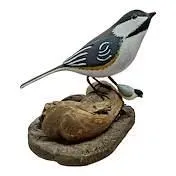 Sale Photo Thumbnail #17: Hand-carved and painted wooden bird figurine perched on a natural driftwood base, featuring detailed plumage accents.