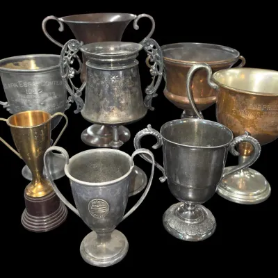 Sale Photo Thumbnail #149: Collection of eight antique and vintage metallic trophy cups in various sizes, styles, and finishes, including engraved silver-tone, brass, and copper examples.