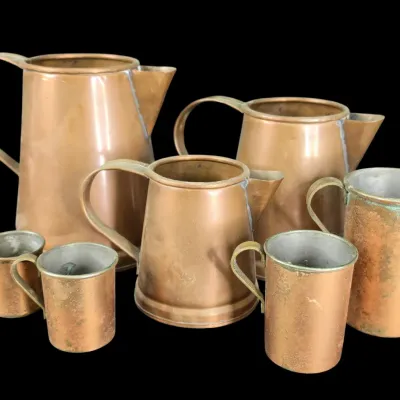 Sale Photo Thumbnail #55: Collection of vintage copper pitchers and measuring cups with tin-lined interiors, showing natural patina and wear.