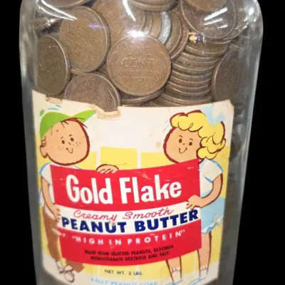 Sale Photo Thumbnail #154: Vintage Gold Flake Peanut Butter glass jar filled with mid-century wheat cents and copper pennies.