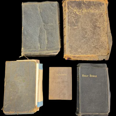Sale Photo Thumbnail #123: Collection of five antique and vintage religious books, including leather-bound Holy Bibles and a volume of The Proverbs, showing heavy wear and age.
