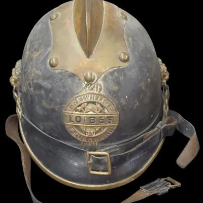 Sale Photo Thumbnail #143: Antique German or Austrian volunteer fire brigade helmet featuring brass crest, chin strap, and front badge reading 'Freiwillige Feuerwehr Loibes'.