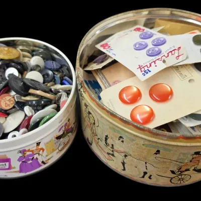 Sale Photo Thumbnail #34: Two round vintage tin containers filled with assorted sewing buttons, including loose buttons and original carded button sets.