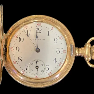 Sale Photo Thumbnail #128: Antique Waltham gold-filled hunter case pocket watch with an open face, white dial, Arabic numerals, and a sub-seconds dial.