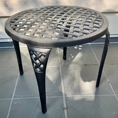 Sale Photo Thumbnail #286: This  pair of vintage chaise lounges features a durable cast aluminum frame finished in a matte black powder coat, characterized by intricate, lattice-style openwork on the frame and legs. This piece is mounted on two functional wheels, facilitating easy 