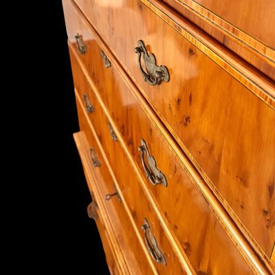 Sale Photo Thumbnail #103: This exquisite Queen Anne style highboy features a classic bonnet-top (or swan's neck) pediment adorned with a central carved shell motif and finials. The piece is constructed with rich, figured walnut veneers, showcasing intricate grain patterns across t