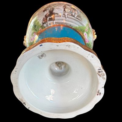 Sale Photo Thumbnail #252: This large decorative French urn features a vibrant teal glazed neck and base, accented with ornate gilded details and handles. The body is decorated with a detailed, hand painted 18th century courting scene. Neo classical design from the late 19th/early 