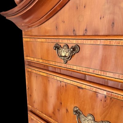 Sale Photo Thumbnail #107: This exquisite Queen Anne style highboy features a classic bonnet-top (or swan's neck) pediment adorned with a central carved shell motif and finials. The piece is constructed with rich, figured walnut veneers, showcasing intricate grain patterns across t