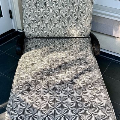 Sale Photo Thumbnail #276: This  pair of vintage chaise lounges features a durable cast aluminum frame finished in a matte black powder coat, characterized by intricate, lattice-style openwork on the frame and legs. This piece is mounted on two functional wheels, facilitating easy 