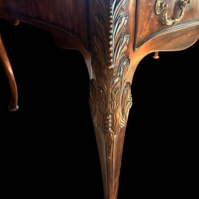Sale Photo Thumbnail #75: This is a stunning Theodore Alexander partners style writing desk constructed with solid mahogany wood with a beautiful leather tooled top. A rich warm finish showcases the natural grain pattern. The front features a series of 4 drawers equipped with orna