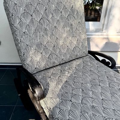 Sale Photo Thumbnail #275: This  pair of vintage chaise lounges features a durable cast aluminum frame finished in a matte black powder coat, characterized by intricate, lattice-style openwork on the frame and legs. This piece is mounted on two functional wheels, facilitating easy 