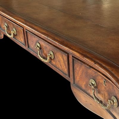 Sale Photo Thumbnail #66: This is a stunning Theodore Alexander partners style writing desk constructed with solid mahogany wood with a beautiful leather tooled top. A rich warm finish showcases the natural grain pattern. The front features a series of 4 drawers equipped with orna