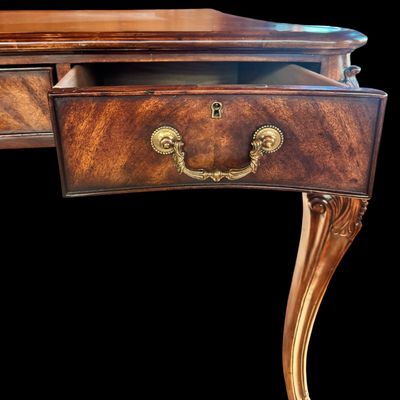Sale Photo Thumbnail #77: This is a stunning Theodore Alexander partners style writing desk constructed with solid mahogany wood with a beautiful leather tooled top. A rich warm finish showcases the natural grain pattern. The front features a series of 4 drawers equipped with orna