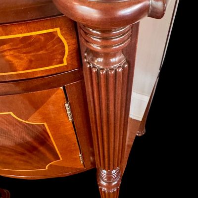 Sale Photo Thumbnail #89: Elegant and high quality Kindel Furniture sideboard executed in the Federal Style with refined neoclassical elements. It features a bow front design, characteristic of the period with flame mahogany veneers, and contrasting stringing inlay. The piece is s