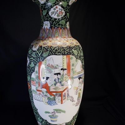 Sale Photo Thumbnail #253: Pair of large, decorative Chinese porcelain vase featuring a black-ground ‘Famille Noire’ palette. The vase showcases intricate polychrome enamel decoration, depicting courtly figures in a garden setting, framed by dense floral and foliate patterns on