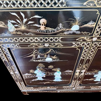 Sale Photo Thumbnail #181: A large black lacquer and mother-of-pearl inlaid figural sideboard depicting the popular “Royal Ladies” narrative scene. Constructed with four central cabinet doors and four upper drawers. The craftsmanship reflects the traditional East Asian furnitur