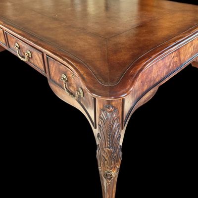 Sale Photo Thumbnail #70: This is a stunning Theodore Alexander partners style writing desk constructed with solid mahogany wood with a beautiful leather tooled top. A rich warm finish showcases the natural grain pattern. The front features a series of 4 drawers equipped with orna