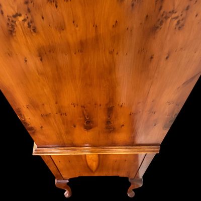 Sale Photo Thumbnail #114: This exquisite Queen Anne style highboy features a classic bonnet-top (or swan's neck) pediment adorned with a central carved shell motif and finials. The piece is constructed with rich, figured walnut veneers, showcasing intricate grain patterns across t