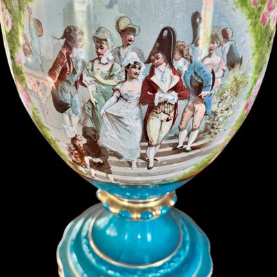 Sale Photo Thumbnail #249: This large decorative French urn features a vibrant teal glazed neck and base, accented with ornate gilded details and handles. The body is decorated with a detailed, hand painted 18th century courting scene. Neo classical design from the late 19th/early 