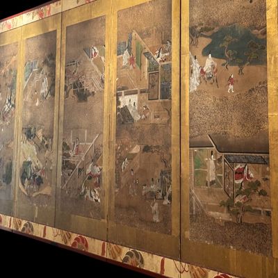 Sale Photo Thumbnail #4: Impressive Japanese eight-panel folding screen featuring hand painted narrative scenes of figures in traditional dress, architecture, and landscapes in muted earth tones with colorful accents. The paintings are framed by gold tone borders, decorative silk