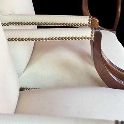 Sale Photo Thumbnail #145: Handsome pair of Chippendale style arm chairs featuring a high, slightly arched back and fluted, dark stained wooden arms and legs. The chairs are upholstered in a neutral chevron pattern fabric, accented with decorative brass tone nailhead trim along the