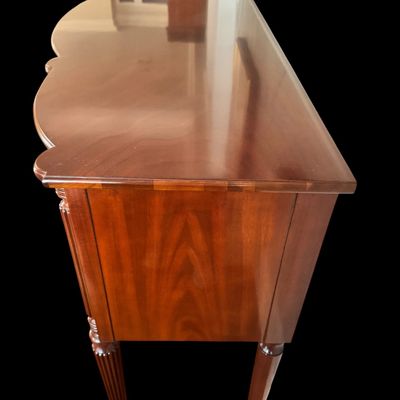 Sale Photo Thumbnail #94: Elegant and high quality Kindel Furniture sideboard executed in the Federal Style with refined neoclassical elements. It features a bow front design, characteristic of the period with flame mahogany veneers, and contrasting stringing inlay. The piece is s