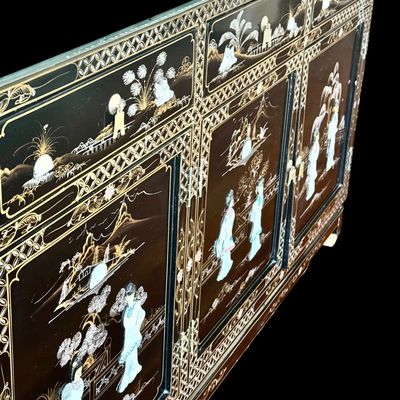 Sale Photo Thumbnail #178: A large black lacquer and mother-of-pearl inlaid figural sideboard depicting the popular “Royal Ladies” narrative scene. Constructed with four central cabinet doors and four upper drawers. The craftsmanship reflects the traditional East Asian furnitur