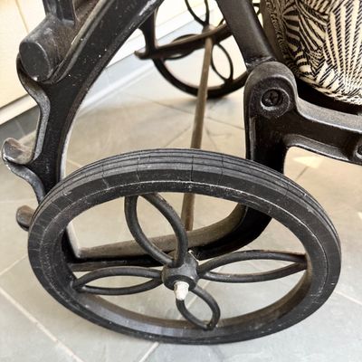 Sale Photo Thumbnail #285: This  pair of vintage chaise lounges features a durable cast aluminum frame finished in a matte black powder coat, characterized by intricate, lattice-style openwork on the frame and legs. This piece is mounted on two functional wheels, facilitating easy 