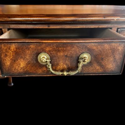 Sale Photo Thumbnail #78: This is a stunning Theodore Alexander partners style writing desk constructed with solid mahogany wood with a beautiful leather tooled top. A rich warm finish showcases the natural grain pattern. The front features a series of 4 drawers equipped with orna