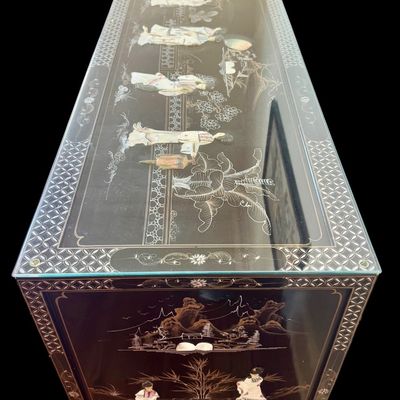 Sale Photo Thumbnail #176: A large black lacquer and mother-of-pearl inlaid figural sideboard depicting the popular “Royal Ladies” narrative scene. Constructed with four central cabinet doors and four upper drawers. The craftsmanship reflects the traditional East Asian furnitur