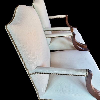 Sale Photo Thumbnail #143: Handsome pair of Chippendale style arm chairs featuring a high, slightly arched back and fluted, dark stained wooden arms and legs. The chairs are upholstered in a neutral chevron pattern fabric, accented with decorative brass tone nailhead trim along the