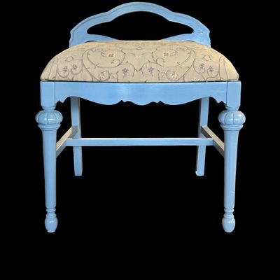 Sale Photo Thumbnail #267: This charming vintage vanity bench features a refined, scalloped apron and distinctive turned legs with bulbous decorative accents. The frame has been painted in a soft muted blue paint, while the seat is upholstered in a durable, neutral toned fabric fea