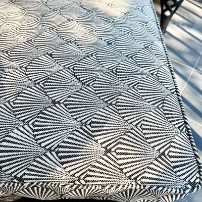 Sale Photo Thumbnail #278: This  pair of vintage chaise lounges features a durable cast aluminum frame finished in a matte black powder coat, characterized by intricate, lattice-style openwork on the frame and legs. This piece is mounted on two functional wheels, facilitating easy 