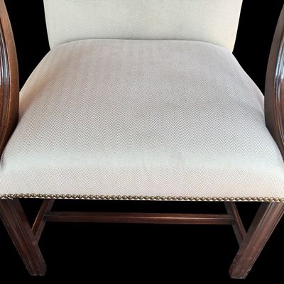 Sale Photo Thumbnail #150: Handsome pair of Chippendale style arm chairs featuring a high, slightly arched back and fluted, dark stained wooden arms and legs. The chairs are upholstered in a neutral chevron pattern fabric, accented with decorative brass tone nailhead trim along the